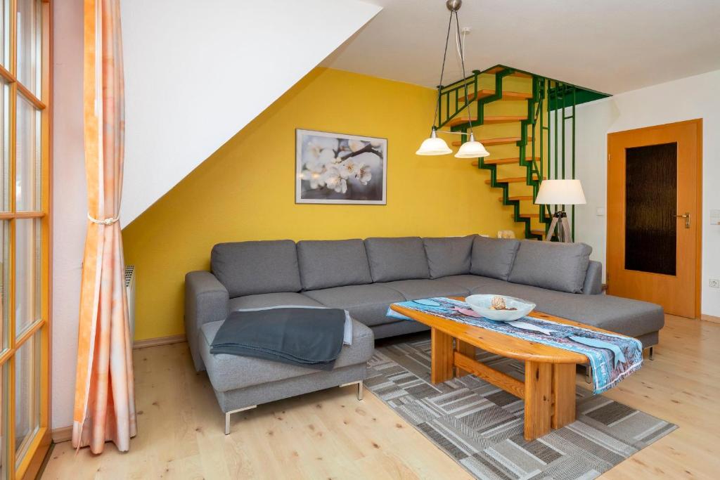 un soggiorno con divano e tavolo di Ferienpark Freesenbruch Wohnung 1 5 - Amber a Zingst