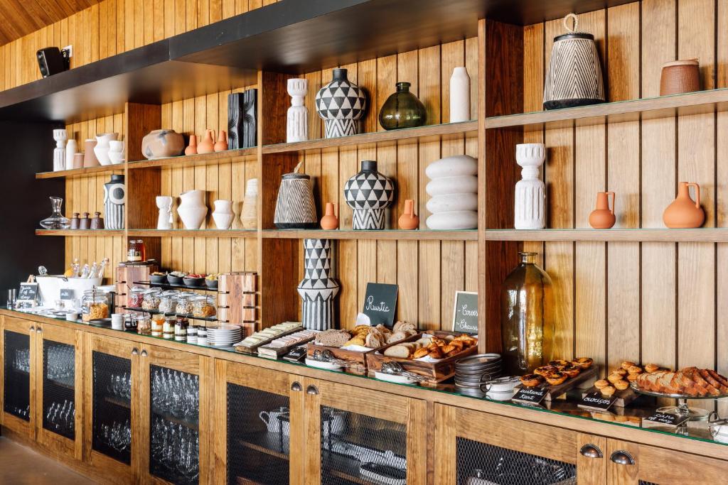 a shelf filled with vases and other ceramics at Immerso Hotel, a Member of Design Hotels in Ericeira