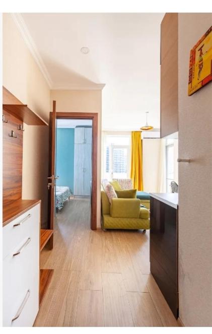 a kitchen and living room with a yellow chair in it at 1BR Cozy apartment in Batumi