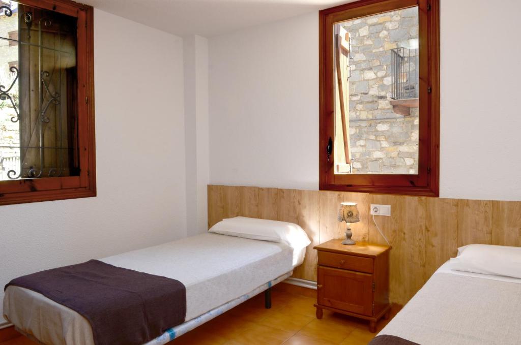 a room with two beds and two windows at La Coma in Taüll