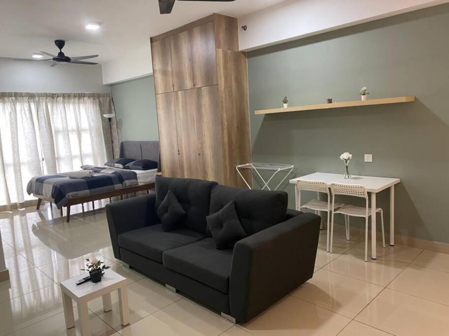 uma sala de estar com um sofá e uma cama em HA12 Cyberjaya, Netflix, Wifi, Free Parking, 3023 em Cyberjaya