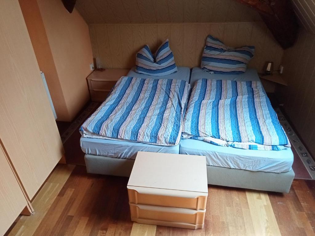 - 2 lits jumeaux dans une petite chambre avec une table dans l'établissement Übernachtungszimmer 1, à Schlettau