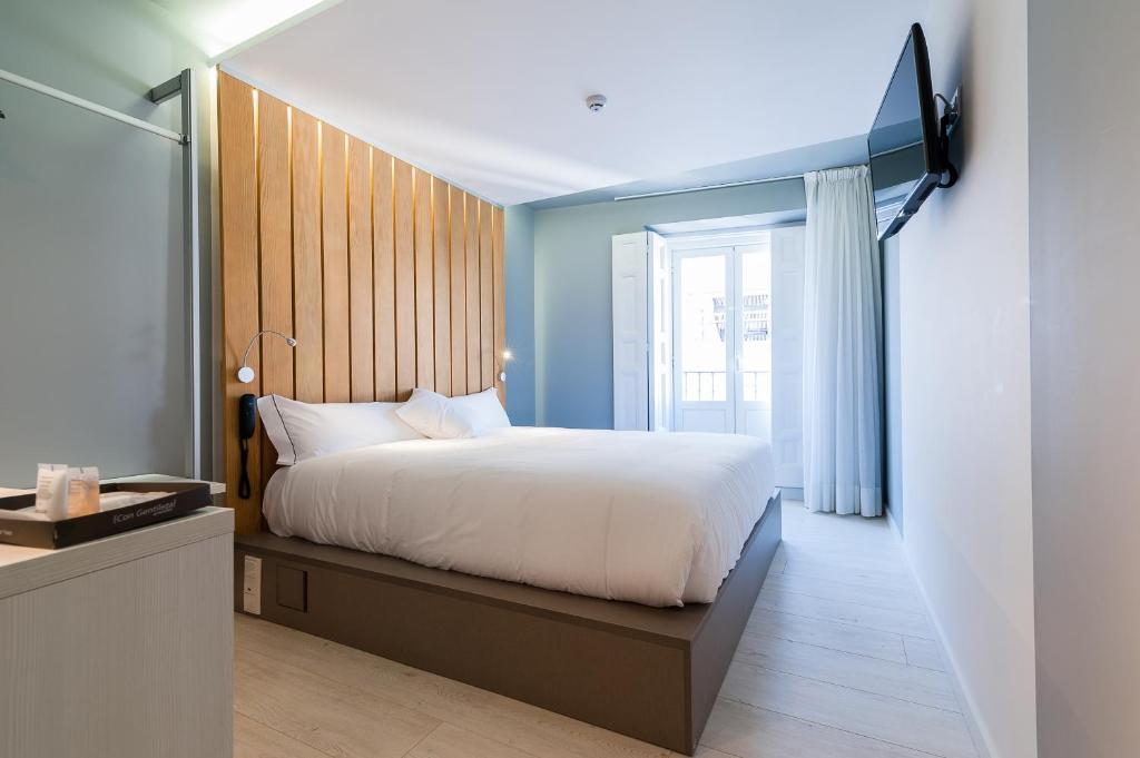 Un dormitorio con una gran cama blanca y una ventana en B&B HOTEL Madrid Centro Fuencarral 52, en Madrid