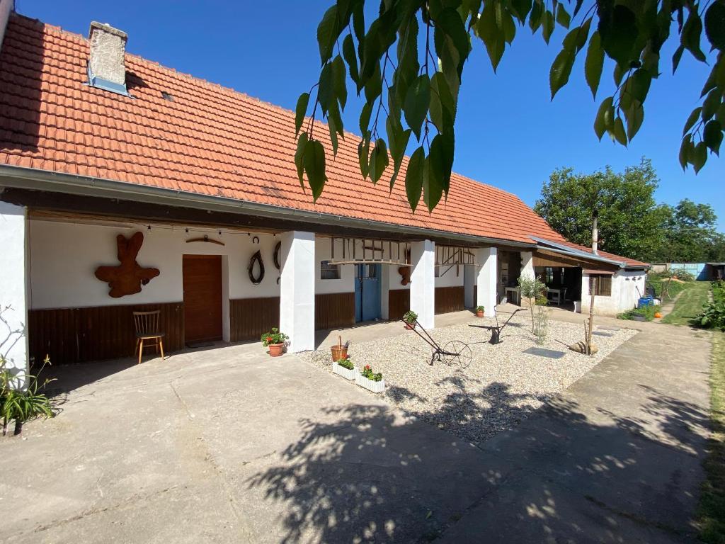 a white house with a red roof and a patio at Rodinný penzion Mayer in Pouzdřany