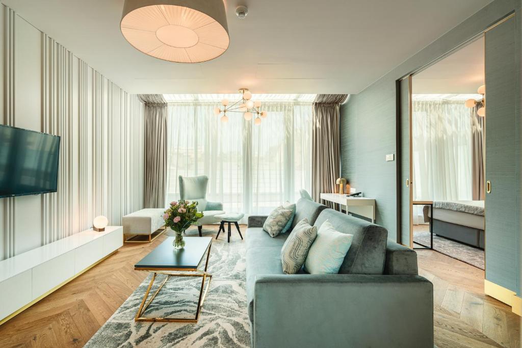 a living room with a couch and a tv at Hotel Ferreus Modern Art Deco in Krakow