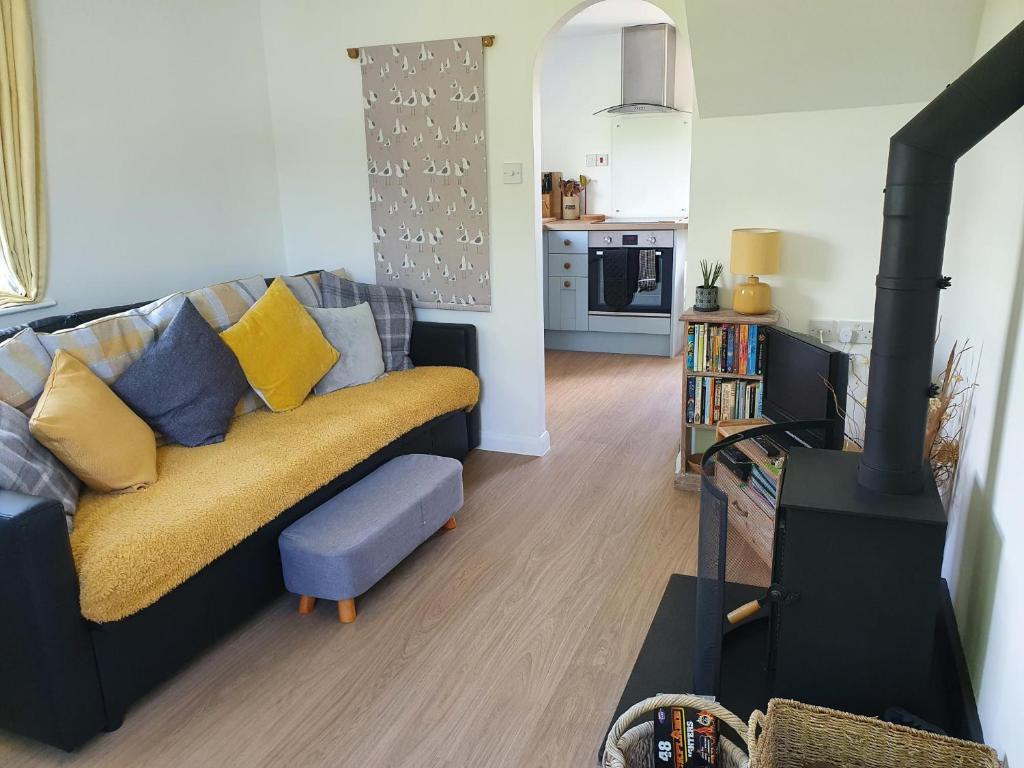 a living room with a couch and a stove at Boots Cottage in Bude
