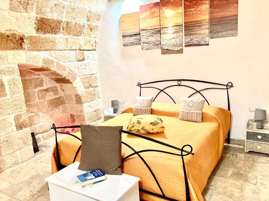 a bedroom with a bed and a stone wall at Antica Pietra in Polignano a Mare