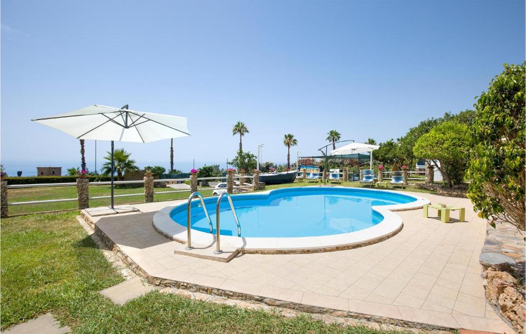 una piscina con ombrellone e prato di Amazing Home In Cittadella Del Capo With Private Swimming Pool, Can Be Inside Or Outside a Cittadella del Capo