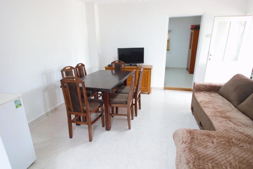 a living room with a table and chairs and a couch at Apartman Rakić in Soko Banja
