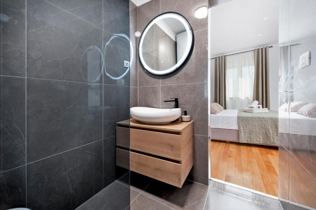 羅維尼的住宿－Jazz Rooms and Apartments，一间带水槽和镜子的浴室