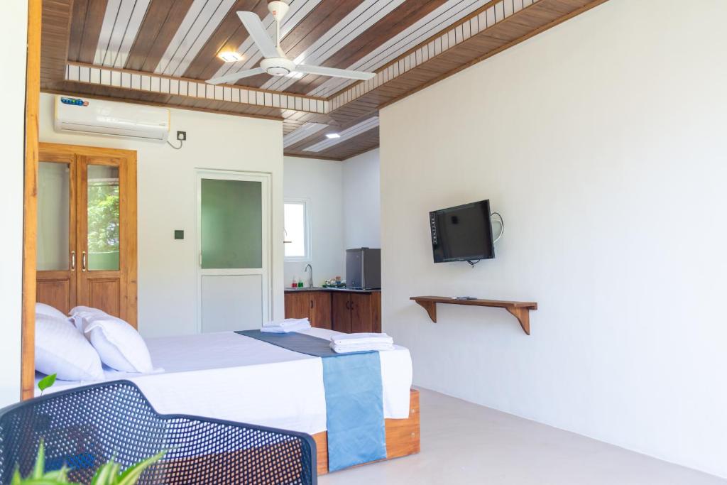 a bedroom with a bed and a tv on a wall at Western sky in Negombo