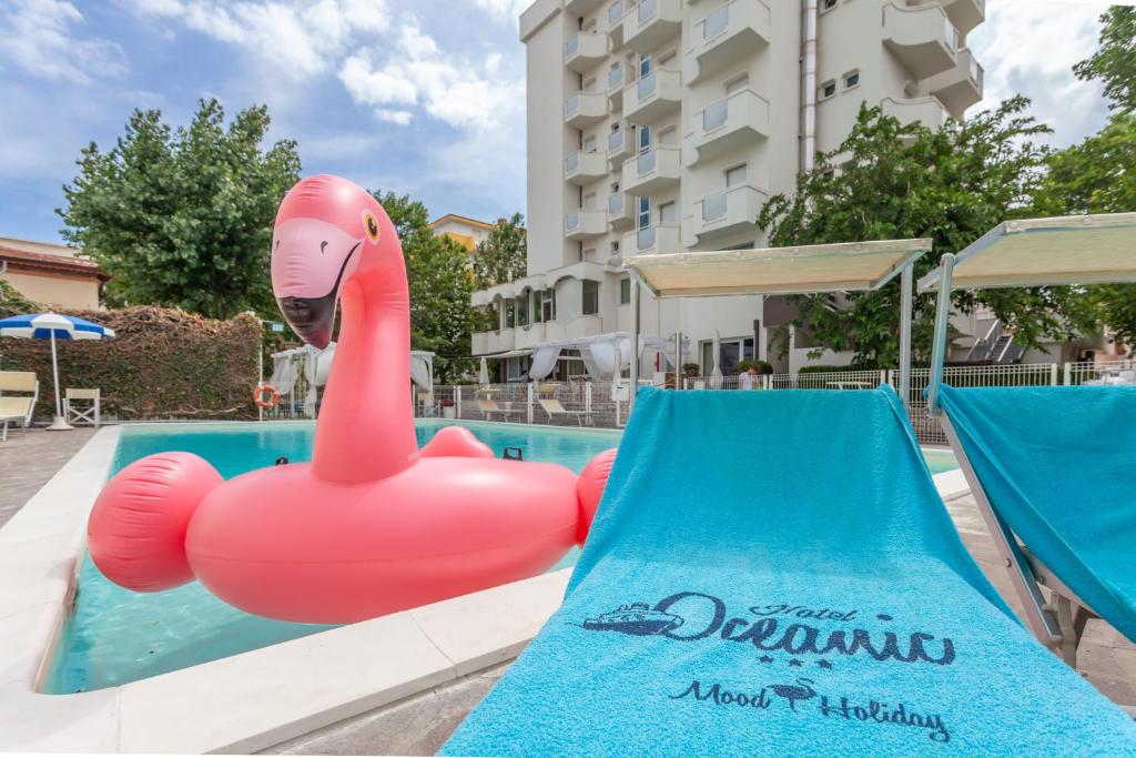 een roze opblaasbare flamingo in een zwembad bij Hotel Oceanic in Rimini