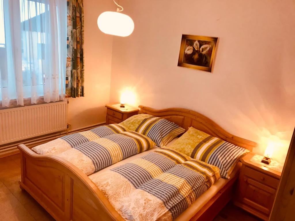 um quarto com uma cama de madeira e 2 almofadas em Braunegger-Hof Waldviertel em Braunegg