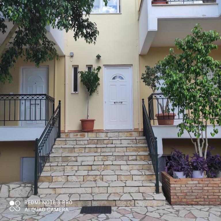a white door on a house with stairs at ARETI 3 in Petalidi