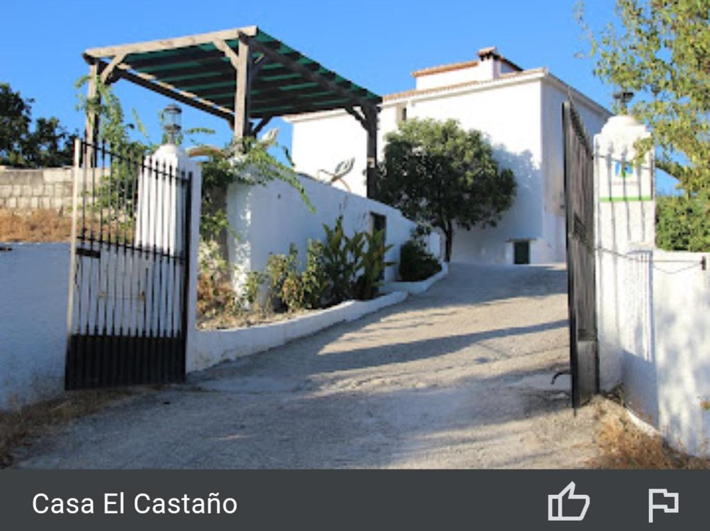 una puerta a una casa blanca con una valla en Casa el Castano, en Martos