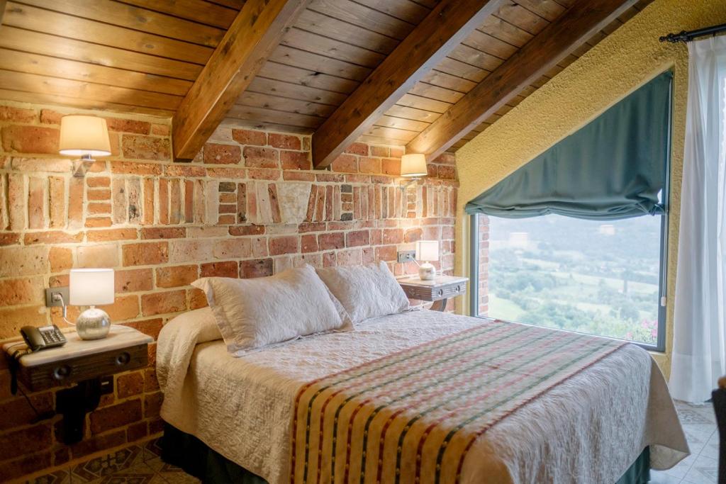 Un dormitorio con una cama y una ventana grande. en Hotel Cerro La Nina, en Beceña