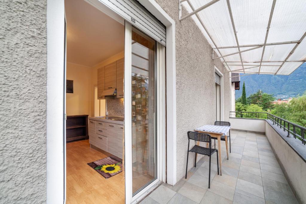 einen Balkon mit einem Tisch und eine Küche mit Aussicht in der Unterkunft Residence Hubertus Apartment 4 in Meran