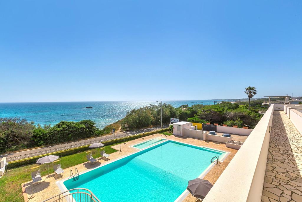 a swimming pool with the ocean in the background at Residence Solaris in San Foca