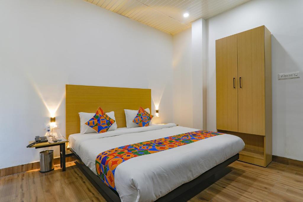 a bedroom with a large bed and a cabinet at FabHotel Super 3 Premium II in Kānpur