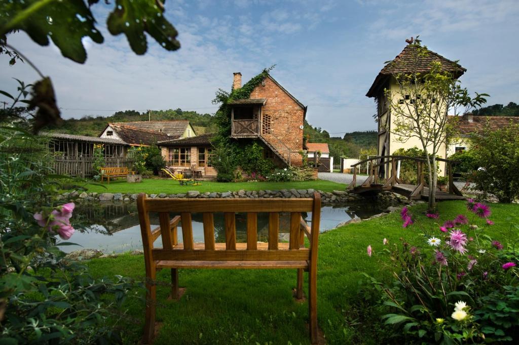 a wooden bench sitting in the grass in front of a house at Country House Stara Kapela in Nova Kapela