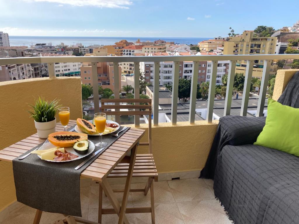 a balcony with a table with food and drinks on it at Preciosas habitaciones en la casa de May in Arona