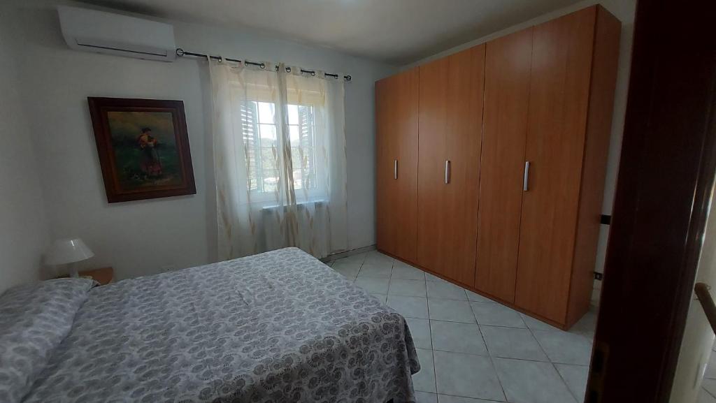 sypialnia z łóżkiem i drewnianą szafką w obiekcie Casa Ariel w mieście Casa Leonardi