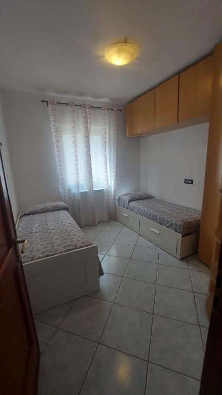 mały pokój z 2 łóżkami i oknem w obiekcie Casa Ariel w mieście Casa Leonardi
