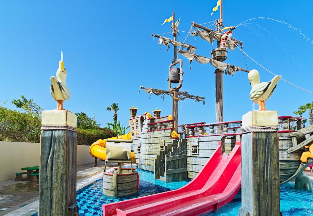a water park with a slide and a playground at Leonardo Cypria Bay in Paphos