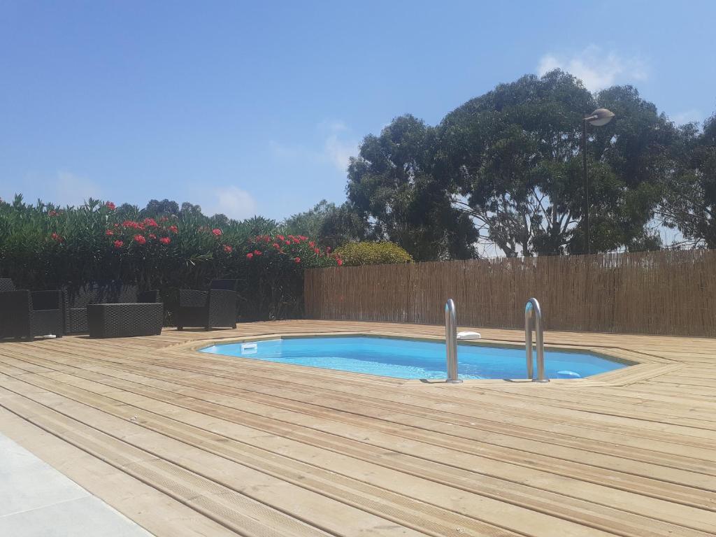 une petite piscine avec une terrasse en bois dans l'établissement Villa san salvador Torreilles plage, à Torreilles