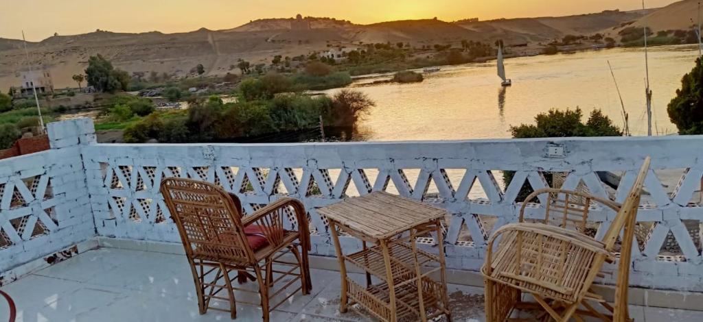 a table and chairs on a balcony with a view of a river at KEKA House in Aswan