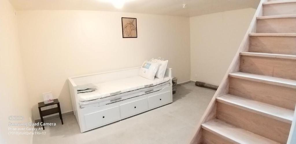 Habitación con cama blanca y escaleras en Appartement une chambre proche PARIS, en Argenteuil