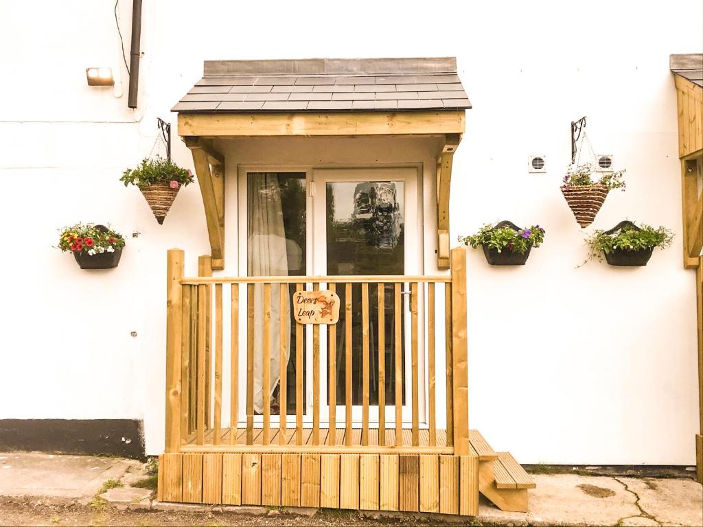 a front door of a house with potted plants at Deers Leap, A modern new personal double bedroom holiday let in The Forest Of Dean in Blakeney