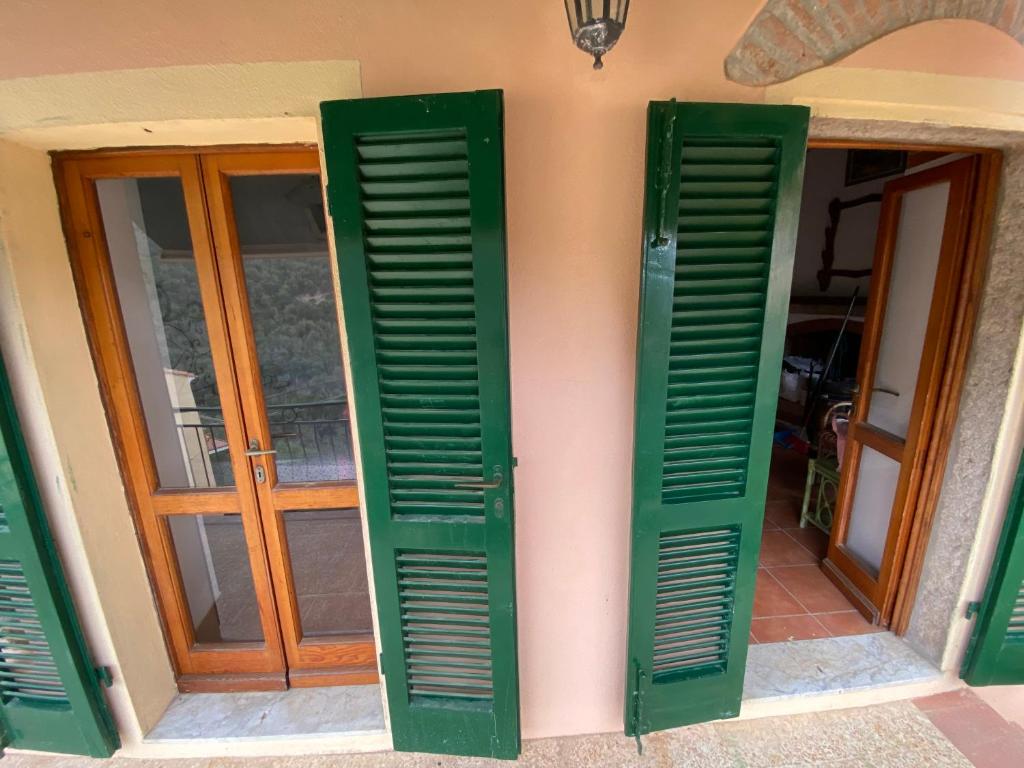 a pair of green shutters on a house at Casa marciana alta in Marciana