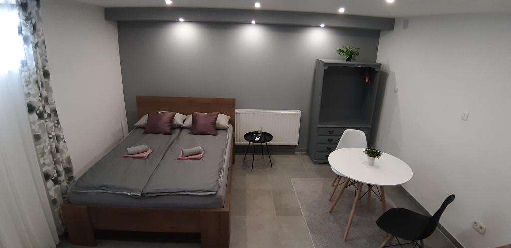 ein kleines Zimmer mit einem Bett und einem Tisch in der Unterkunft Apartments Jack in Bihać