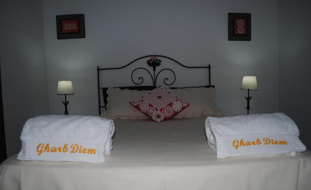 a bedroom with a bed with two white towels on it at Apartamentos Gharb Diem in Tavira