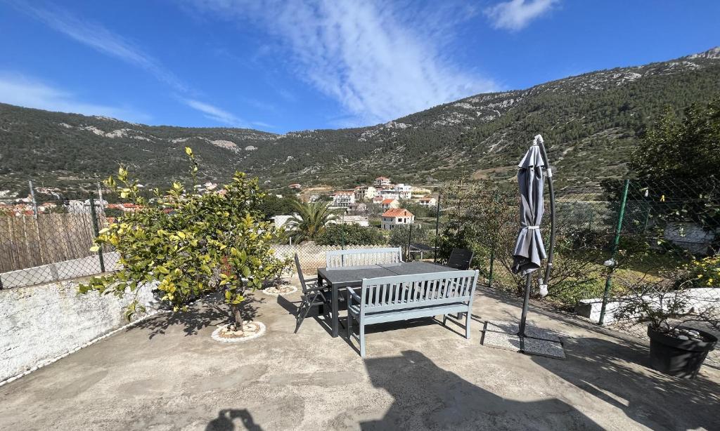 a bench and an umbrella on a patio with a view at Villa Ines in Komiža