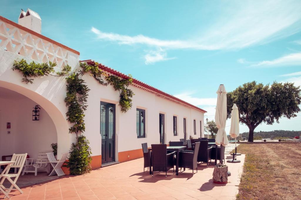 a patio with a table and chairs and a building at Herdade Vale de Cabras in Portel