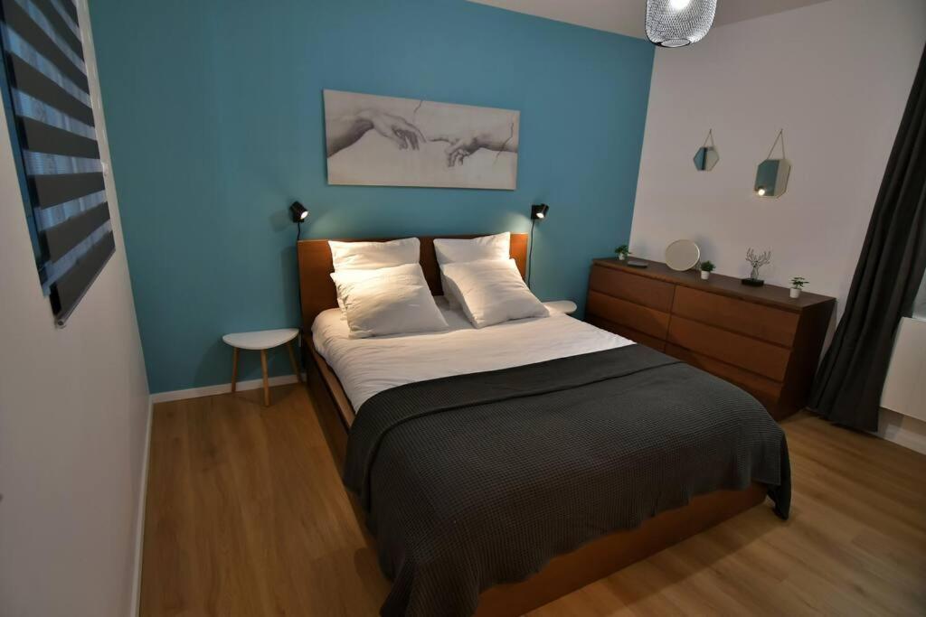 a bedroom with a bed with a blue wall at Le 46 - T2 rénové, confortable proche centre-ville in Montluçon