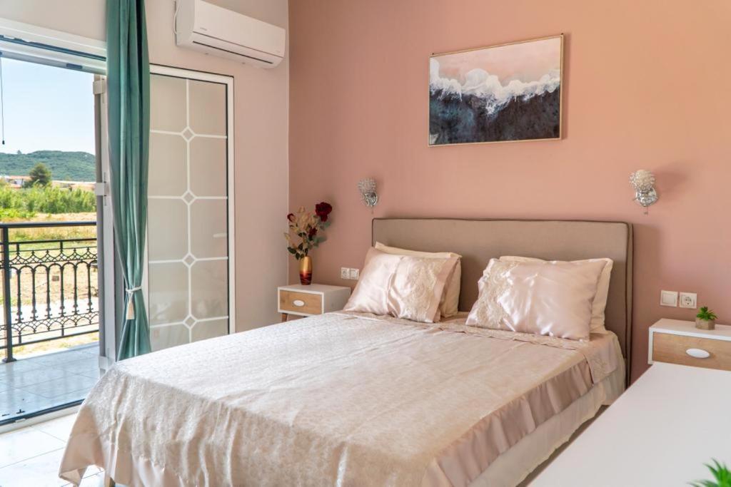a bedroom with a large bed and a balcony at Central Apartments in Alikanas