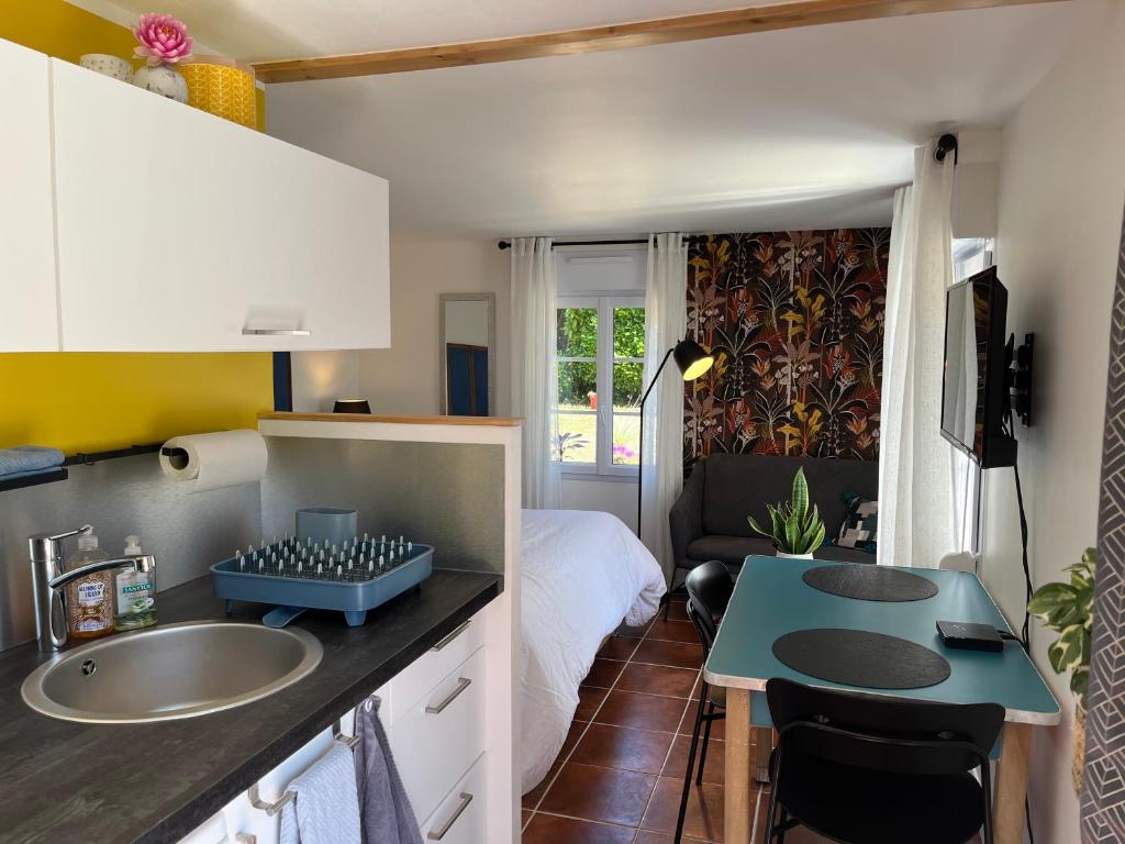 a small bathroom with a sink and a bedroom at Gîte cosy sur jardin in Moëlan-sur-Mer