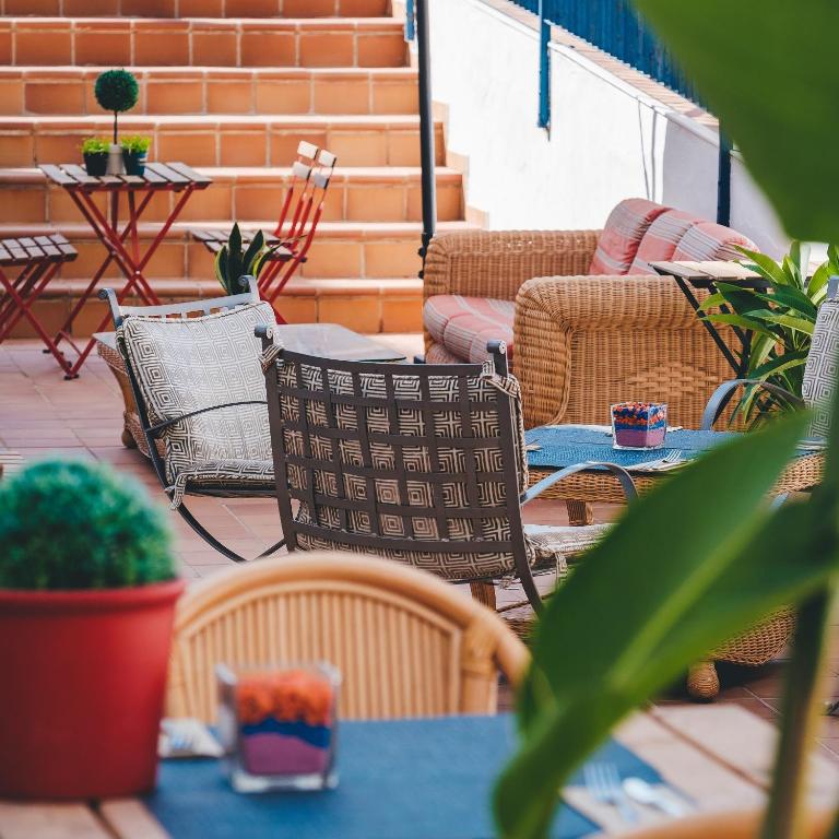 a patio with chairs and a table and a couch at Hotel Don Ignacio in San José