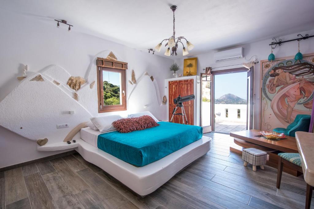 um quarto com uma cama grande e uma janela grande em ELaiolithos Luxury Retreat Hotel & Suites - Adults Only em Khalkíon