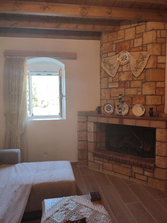 salon z kominkiem z cegły i oknem w obiekcie Villa Jimmy, Pilona Village w mieście vlicha