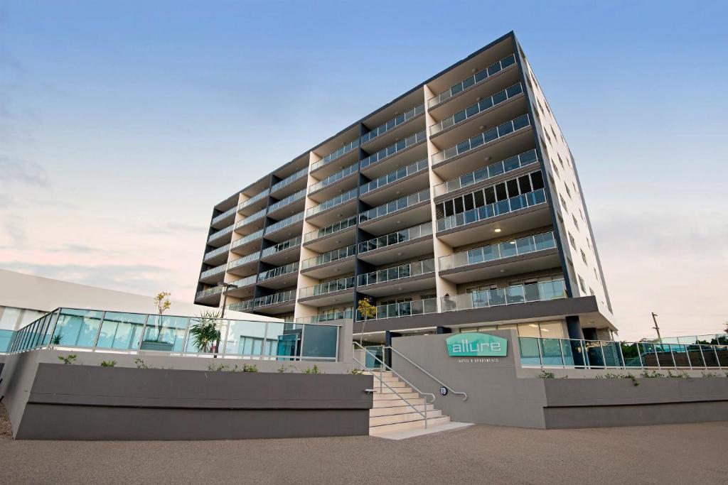 a large building with a staircase in front of it at Allure Hotel & Apartments in Townsville