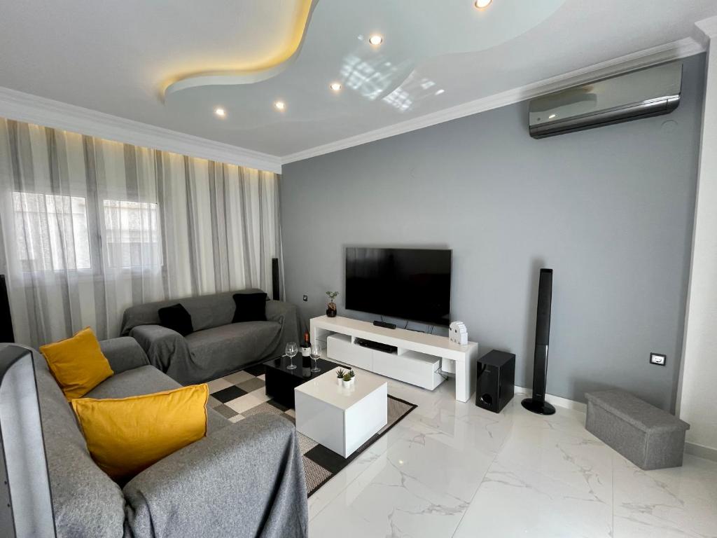a living room with a couch and a tv at Luxurious Modern Home in Kalamaria, Thessaloniki in Thessaloniki