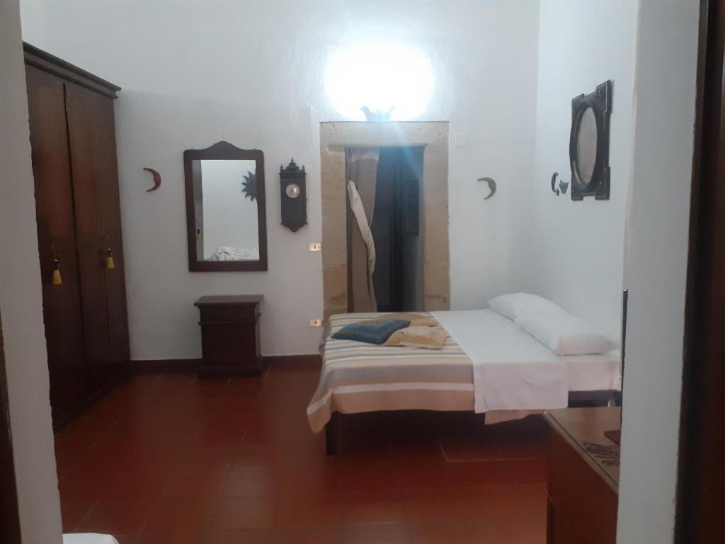 een slaapkamer met een bed, een licht en een spiegel bij Da Nonna Isa in Tropea