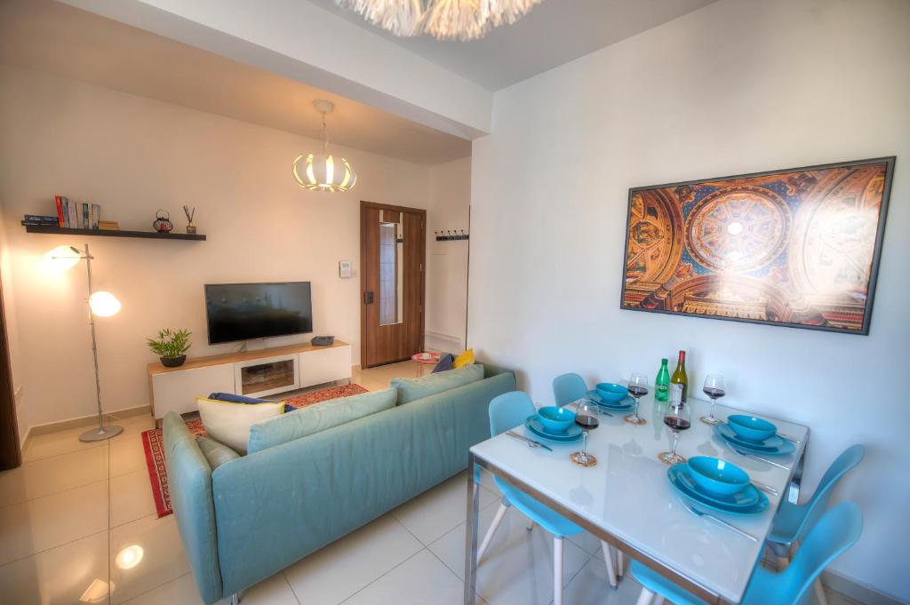 sala de estar con sofá azul y mesa en Charming 2 bedroom apartment close to Junior College ETUS1-1, en Msida