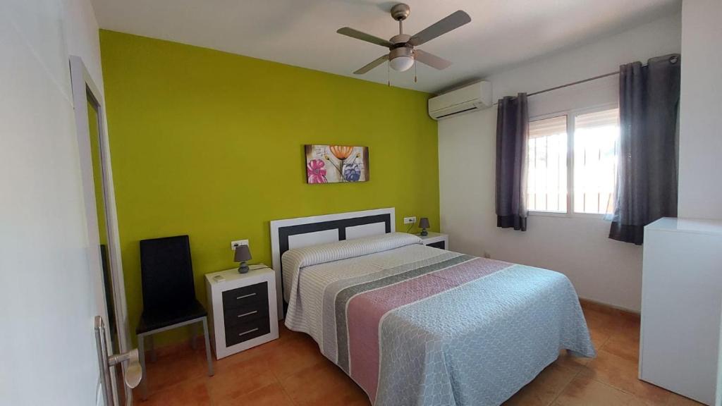 1 dormitorio con cama y pared verde en Apartamento Sirena, en Almuñécar