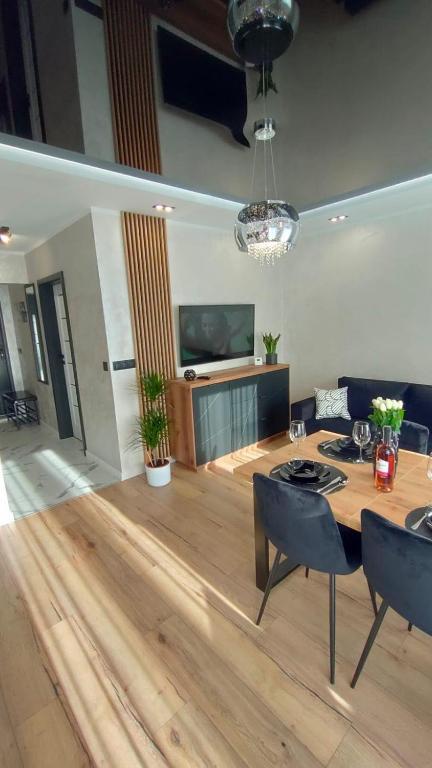 a living room with a table and chairs and a television at Haven Apart Karpacz in Karpacz