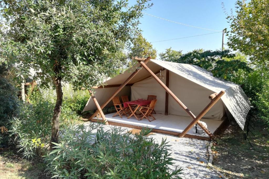 a tent with a table and chairs in it at Glamping Agricampeggio Tognoni in La Sdriscia
